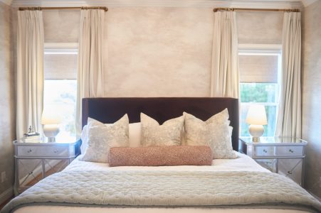 Bedroom with dark upholstered bed and floor-length drapery