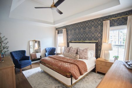 Bedroom with blue accent wall, upholstered bed and blue armchairs
