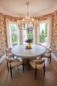 Breakfast nook with red floral wallpaper, bay window and round table