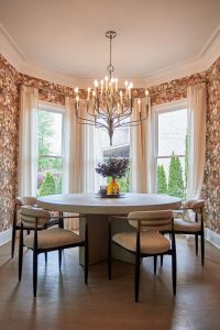 Floral wallpapered breakfast nook with round table and chandelier