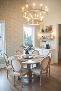 Dining nook with round table, chandelier and patterned wallpaper