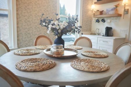 Dining table set with floral centerpiece and layered chargers