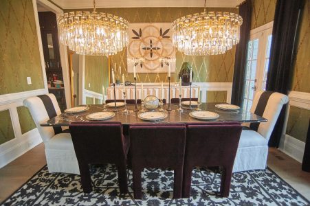 Formal dining room with olive grasscloth, dark table and crystal chandelier