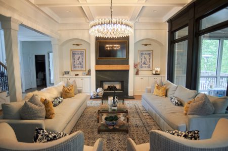 Great room with blue sofas, fireplace and yellow accent pillows