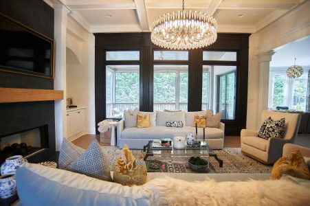 Great room with blue sofas, staircase view and chandelier