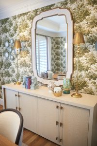 Green botanical wallpaper with mirror above a styled console