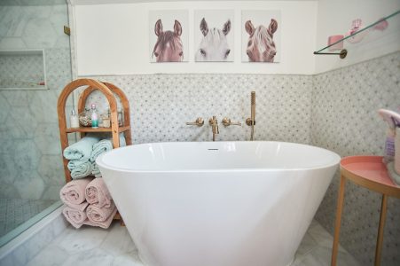 Children's bathroom with freestanding tub and playful art