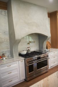 Kitchen with professional range, plaster hood and marble island