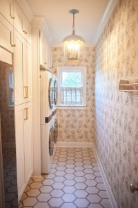 Atlanta laundry room with floral wallpaper, hexagon tile floor and concealed washer and dryer