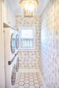 Floral wallpapered laundry room with hexagon tile and window