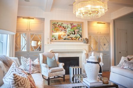 Living room with fireplace, statement art and white accent chairs