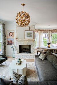 Living room with fireplace, gray sofa and woven sphere chandelier