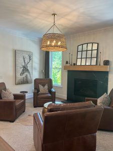 Living room with leather chairs, fireplace and brass drum coffee table