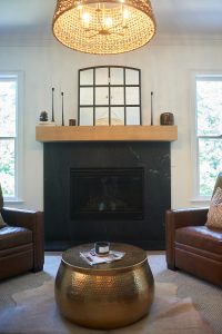 Living room with leather chairs, fireplace and chunky wood mantel