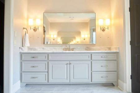 Master bathroom with double vanity, large mirror and sconces