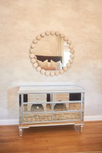 Mirrored chest with round mirror styled as an entry vignette