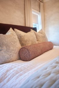 Neutral bedroom with layered bedding and warm plaster walls