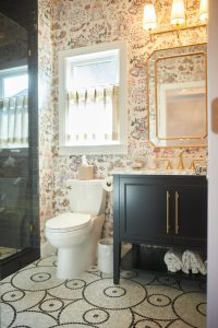 Powder room with bold floral wallpaper and black vanity