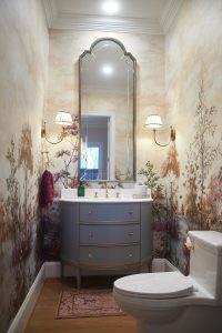 Powder room with scenic mural wallpaper, blue vanity and arched mirror
