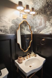 Powder room with scenic mural wallpaper and organic gold mirror