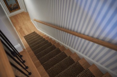 Striped wallpaper staircase with patterned runner