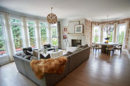 Sunroom with gray sectional, bay window and cowhide rug
