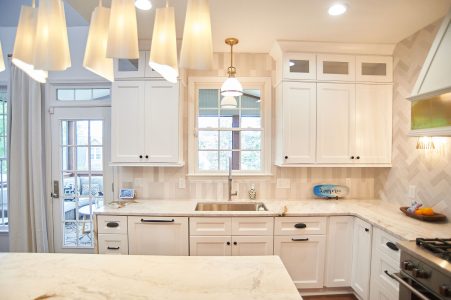 White kitchen with soft drapery framing the window