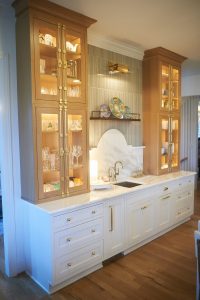 White kitchen with illuminated glass-front display cabinets