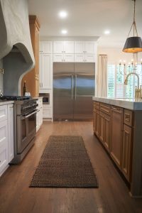 Wood-toned kitchen with range and hallway view