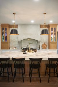 Wood-toned kitchen with white island and bar stool seating